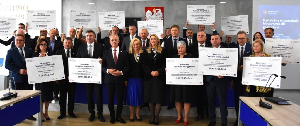 Grupa ludzi trzyma tablice z napisami 